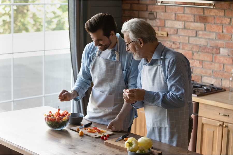 Father's Day cooking class. Father and son cutting vegetables in a kitchen